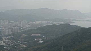 DCA02_025 - 4K aerial stock footage pan from Tolo Harbor to reveal Tai Po apartment buildings in the New Territories, Hong Kong, China