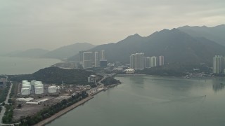 DCA02_036 - 4K aerial stock footage of jet fuel tanks near apartment complexes in Tung Chung, Lantau Island, Hong Kong, China