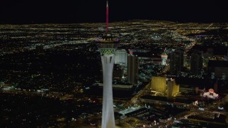 DCA03_006 - 4K aerial stock footage of orbiting top of Stratosphere with city sprawl in background, Las Vegas, Nevada Night