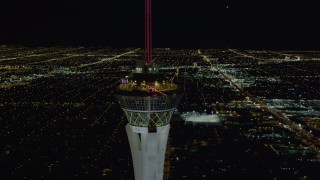 DCA03_007 - 4K aerial stock footage of orbiting top of Stratosphere with city sprawl in background, Las Vegas, Nevada Night