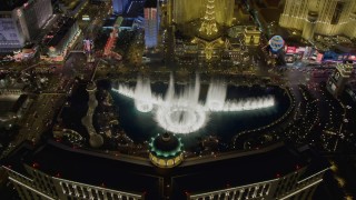 DCA03_023 - 4K aerial stock footage of flying over The Bellagio with Paris in background, tilting to the water show, Las Vegas, Nevada Night