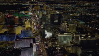 DCA03_129 - 4K aerial stock footage of hotels along Las Vegas Strip, approaching Paris and Bellagio Fountain water show, Nevada Night