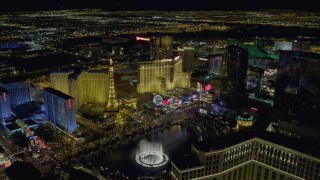 DCA03_194 - 4K aerial stock footage of flying over Bellagio Fountain toward Paris Hotel and Casino, Las Vegas, Nevada Night