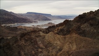 DCA04_081 - 4K aerial stock footage of flying over rocky ridges toward Lake Mead, Hiller Mountains, Nevada