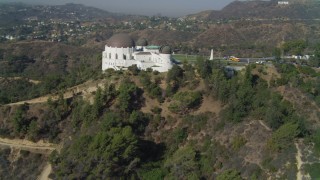 DCA05_016 - 4K aerial stock footage tilt up hill, revealing Griffith Observatory, Los Angeles, California