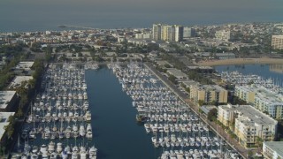 DCA05_071 - 4K aerial stock footage pass boats in the marina, tilt to apartments, Marina Del Rey, California