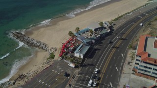 DCA05_099 - 4K aerial stock footage of Highway 1 along the coast, tilt to restaurant, Pacific Palisades, California