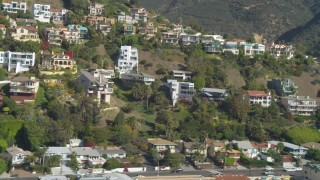 DCA05_115 - 4K aerial stock footage of flying by hillside homes, focusing on custom home, Malibu, California