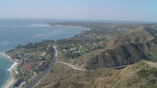 DCA05_125 - 4K aerial stock footage of flying over a hill, revealing coastal community of Malibu, California
