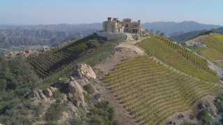 DCA05_138 - 4K aerial stock footage of orbiting winery, vineyards on a hill, Malibu, California