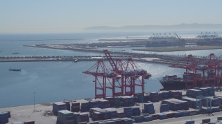 DCA06_041 - 4K aerial stock footage of flying by cargo containers, cranes, reveal cargo ship, Port of Long Beach, California