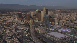 DCA07_015 - 4K aerial stock footage of flying by Highway 110, tilt up to reveal Downtown skyscrapers, Los Angeles, California, twilight