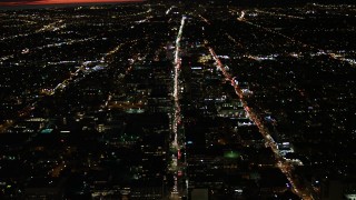 DCA07_066 - 4K stock footage aerial video of following Wilshire Blvd through Koreatown and tilt to a wider view of Los Angeles, California, night