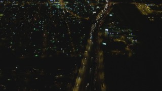 DCA07_120 - 4K aerial stock footage of flying away from Interstate 710, reveal interchange with Highway 91, Long Beach, California, night