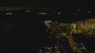 DCA07_125 - 4K aerial stock footage of RMS Queen Mary, Carnival Cruise Lines building, Port of Long Beach, California, night