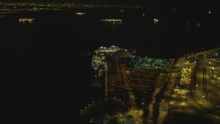 DCA07_126 - 4K aerial stock footage of RMS Queen Mary, Carnival Cruise Lines building, Port of Long Beach, California, night