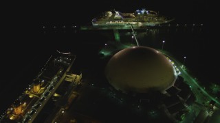 DCA07_127 - 4K aerial stock footage of RMS Queen Mary, Carnival Cruise lines building, cruise ship, Long Beach, California, night