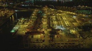 DCA07_129 - 4K stock footage aerial video of flying by cargo cranes, containers, Port of Long Beach, California, night