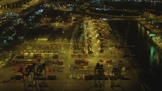 DCA07_130 - 4K stock footage aerial video of flying by cargo containers, cranes, Port of Long Beach, California, night