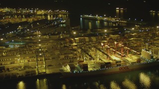 DCA07_135 - 4K stock footage aerial video of flying by cargo ship, cranes, containers, Port of Long Beach, California, night