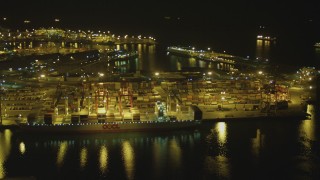 DCA07_136 - 4K stock footage aerial video of approaching cargo ship and cranes at Port of Long Beach, California, night