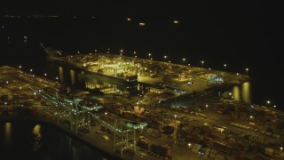 DCA07_140 - 4K aerial stock footage of approaching cargo containers, cranes, Port of Long Beach, California, night