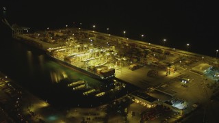 DCA07_141 - 4K aerial stock footage of approaching cargo ship and cranes, Port of Long Beach, California, night