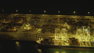 DCA07_142 - 4K stock footage aerial video of flying by cargo ship, cranes and containers at Port of Long Beach, California, night