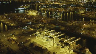 DCA07_145 - 4K aerial stock footage tilt from cargo ship to wider view of Port of Long Beach, California, night