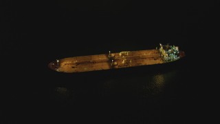 DCA07_148 - 4K aerial stock footage of an orbit of an oil tanker sailing near Port of Long Beach, California, night