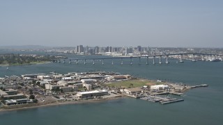DCA08_025 - 4K aerial stock footage of a reverse view of the Coronado Bridge, city skyline, and military base, San Diego, California