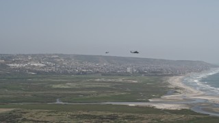 DCA08_035 - 4K aerial stock footage of tracking two military helicopters flying near the coast, Imperial Beach, California