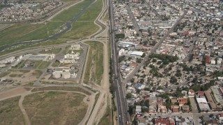 DCA08_046 - 4K aerial stock footage of following a border highway and fence on the US/Mexico Border, Tijuana