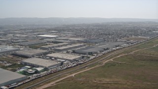 DCA08_073N - 4K aerial stock footage pan across the border fence to reveal warehouse buildings and urban neighborhoods, US/Mexico Border, Tijuana