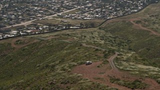 DCA08_076 - 4K aerial stock footage orbit Border Patrol and tilt to reveal Tijuana homes, US/Mexico Border, Tijuana