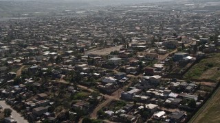 DCA08_077 - 4K aerial stock footage of urban neighborhoods by the border fence, US/Mexico Border, Tijuana