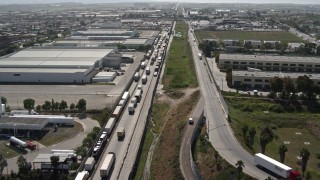 DCA08_083E - 4K aerial stock footage of a line of trucks by warehouses, US/Mexico Border, Tijuana