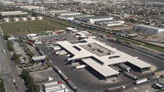 DCA08_087E - 4K aerial stock footage tilt from big rigs to reveal and orbit Otay Mesa Port of Entry on the US/Mexico Border, Otay Mesa, California