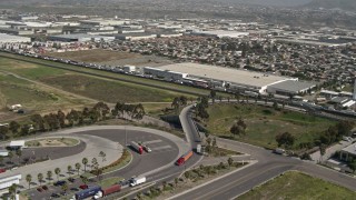 DCA08_094 - 4K aerial stock footage orbit trucks and warehouses on the US/Mexico Border, Tijuana, Mexico