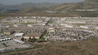 DCA08_102E - 4K aerial stock footage tilt from hill to reveal prison, Otay Mesa, California
