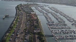 DCA08_177E - 4K aerial stock footage pan across boats at a marina and tilt to reveal island hotel, Shelter Island, California