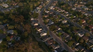 DCA08_275 - 4K aerial stock footage video of a reverse view of tract homes, and reveal the freeway, Bay Ho, California, Sunset