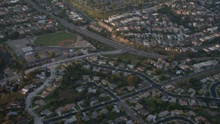 DCA08_283 - 4K aerial stock footage of suburban tract homes, reveal baseball field, Pacific Beach, California, Sunset