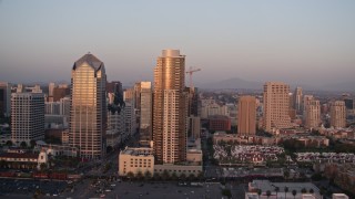 DCA08_307E - 4K aerial stock footage approach and flyby city skyscrapers, Downtown San Diego, California, Sunset