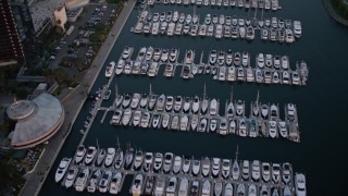 DCA08_313 - 4K aerial stock footage of a reverse view of a marina in Downtown San Diego, California, Sunset