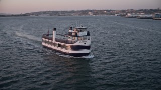 DCA08_314 - 4K aerial stock footage approach and track a ferry sailing San Diego Bay, California, Sunset