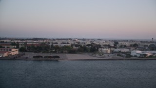 DCA08_316 - 4K aerial stock footage of flying by the Naval Air Station North Island, a military base in San Diego, California, Sunset