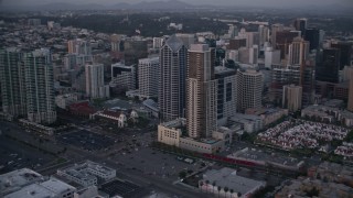 DCA08_322 - 4K aerial stock footage of panning past city skyscrapers and streets in Downtown San Diego, California, Sunset