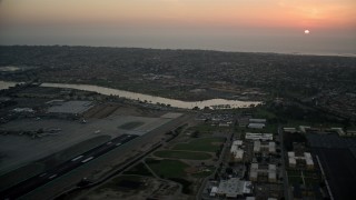 DCA08_328 - 4K aerial stock footage of an airplane taking off from San Diego International Airport, California, Sunset