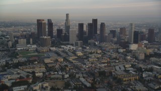 DCLA_015 - 5K aerial stock footage tilt from Hollywood streets to reveal and approach Downtown Los Angeles skyline at sunset, California